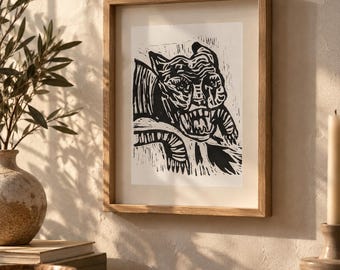 May include: A framed wall art print featuring a black and white linocut illustration of a snarling creature with sharp teeth and textured fur patterns. The artwork is enclosed in a light-toned wooden frame with a clean, rectangular profile.