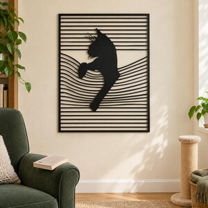 May include: A rectangular black metal wall art piece featuring a silhouette of a cat reaching upward. The design is composed of horizontal lines that transition into curved, wavy lines across the center, creating a layered visual effect.