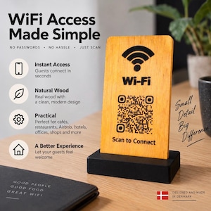 Può includere: Un cartello rettangolare in legno chiaro con base nera, caratterizzato da un'icona Wi-Fi nera, un codice QR e il testo "Wi-Fi" e "Scan to Connect". Il cartello è presentato con del testo che elenca vantaggi come "WiFi Access Made Simple".