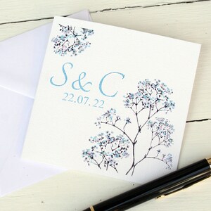 White square card with pretty blue flowers on either side. Blue text: INITIAL & INITIAL DATE