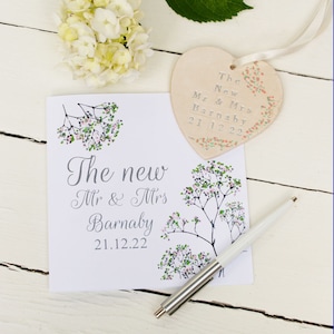 White square card with Pink and green flowers along the side with silver text: The New Mr & Mrs NAME DATE