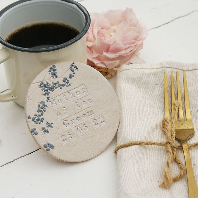 handmade white round ceramic coasters with blue and grey floral design with silver text or mother of the groom and the date