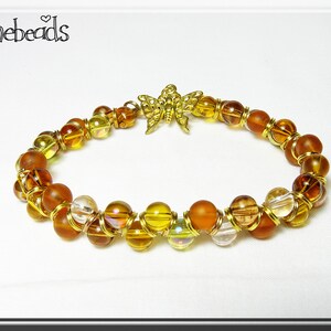 Glass brown and gold bracelet with gold-plated zigzag pattern. Finished with a butterfly charm.