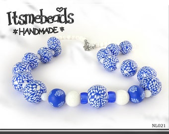 Joli collier en polymère bleu et blanc. Les perles de verre complètent les perles en polymère faites à la main par nos soins, ce qui en fait un collier vraiment unique.