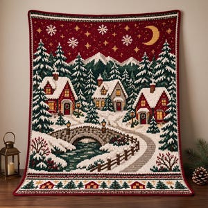 May include: A rectangular crochet blanket featuring a winter village scene with red houses, snow-covered pine trees, a stone bridge over a stream, and a dark red night sky with a yellow crescent moon and white snowflakes, finished with a decorative border.