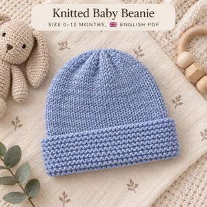 May include: A light blue knitted baby beanie with a textured garter stitch brim and a smooth stockinette stitch crown. The image includes text that reads Knitted Baby Beanie, Size 0-12 Months, English PDF, alongside a crochet bunny toy.