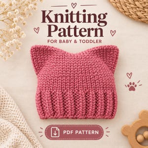 Op de afbeelding: Een oudroze gebreide muts voor baby's en peuters met twee puntige oren en een geribbelde boord. De tekst Knitting Pattern for Baby & Toddler en PDF Pattern staat in donkerbruine letters met kleine hartjes en een pootafdruk-icoon.