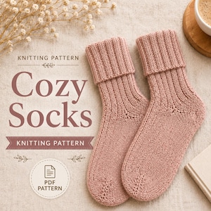 May include: A pair of dusty pink knitted socks with a ribbed cuff design. The image features the text "KNITTING PATTERN Cozy Socks" and a circular icon with a document symbol and the text "PDF PATTERN" indicating a digital knitting pattern.