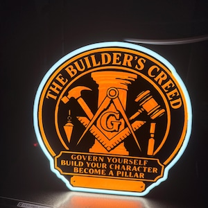 May include: A circular illuminated sign with a bright orange glow featuring the text THE BUILDER'S CREED and GOVERN YOURSELF BUILD YOUR CHARACTER BECOME A PILLAR. The design includes a central pillar, a square and compass with a G, a hammer, and a gavel.