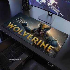 Puede incluir: Una alfombrilla de escritorio rectangular con un gráfico del personaje Wolverine con garras extendidas. La palabra WOLVERINE está impresa en letras grandes, negritas y de color dorado en el centro. El fondo es oscuro con chispas.
