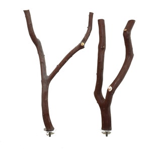 May include: Two brown wooden branches with metal bases for attaching to a cage. The branches are different sizes and shapes, and they have a natural, rustic look.