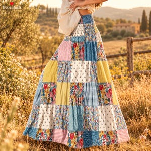 May include: A floor-length patchwork skirt featuring a smocked elastic waistband and a variety of fabric squares in floral, gingham, and polka dot patterns in shades of blue, yellow, red, pink, and white, worn with a light beige top.
