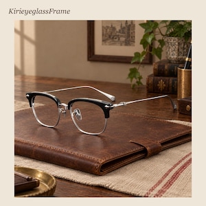 Puede incluir: Gafas con montura browline negra y aros de metal plateado. Las varillas son finas y plateadas con detalles metálicos decorativos en las bisagras. El puente es de metal plateado con plaquetas nasales ajustables.