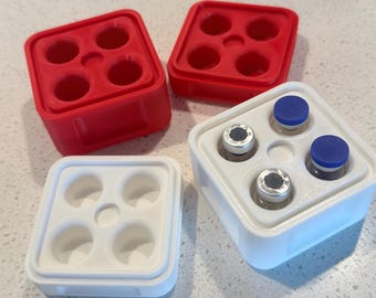 May include: Two red and two white square plastic holders, each featuring four circular cutouts. One white holder contains four small glass vials with blue and silver caps, while the other three holders are empty and displayed separately.