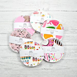May include: A set of six colorful mini washcloths with various patterns, including bicycles, nesting dolls, and animals. The washcloths are made of quilting terry cotton and are labeled "Mini Washcloths".