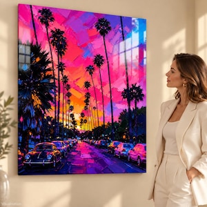 Peut inclure: Une impression d'art mural carrée représentant une scène de rue peinte aux couleurs vives au coucher du soleil. De grands palmiers bordent une route remplie de voitures garées, sous un ciel dramatique aux teintes rose, violet et orange.