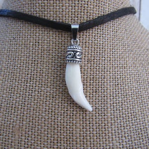 Ketting met hanger in de vorm van een rode vossentand, een symbool van een dierlijk spiritueel dier (Vulpes vulpes).