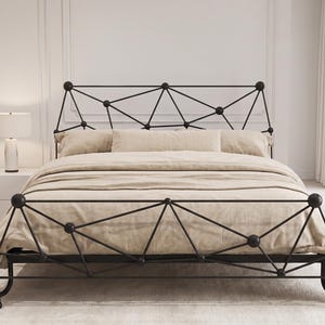 Puede incluir: Una estructura de cama de metal negro con un diseño geométrico de celosía triangular tanto en el cabecero como en el piecero. La cama está vestida con un edredón beige liso y almohadas a juego, mostrando una construcción metálica limpia.