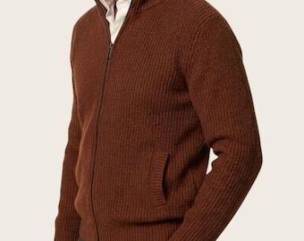 Könnte beinhalten: Eine rostfarbene, gerippte Strickjacke mit Reißverschluss, Stehkragen, langen Ärmeln und zwei Seitentaschen. Das Kleidungsstück wird über einem weißen Hemd mit Kragen getragen. Der Text NOBLE mode ist unten mittig in Weiß aufgedruckt.