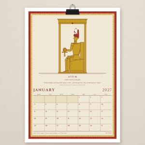 Op de afbeelding: Een wandkalenderpagina voor januari 2027 met een gouden illustratie van de Egyptische godheid Atum zittend in een schrijn. Het ontwerp bevat een rood-gouden rand, de tekst ATUM en een kalenderrooster voor januari 2027.