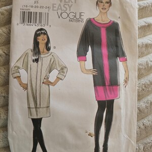 May include: A Very Easy Vogue Patterns sewing pattern envelope V8610, size F5 (16-18-20-22-24). The front displays two illustrations of a dress with three-quarter sleeves and a round neckline. One version is dark gray with pink accents, and the other is light gray.