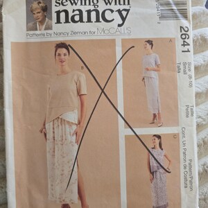 May include: A Sewing with Nancy McCall's pattern envelope 2641 for a two-piece outfit. The front displays three variations of a short-sleeved top and a long skirt with side slits, featuring solid and floral fabric designs with a black X mark.