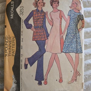 Könnte beinhalten: Eine McCall's 3253 Schnittmusterhülle für ein Kleid oder eine Tunika und eine Hose. Die Vorderseite zeigt Illustrationen von drei Outfits: eine Tunika mit Rautenmuster und Hose, ein ärmelloses Kleid und ein kurzärmeliges gemustertes Kleid.