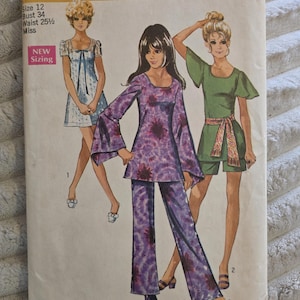 Può includere: Una busta per cartamodello Simplicity 8783 per taglia 12, busto 34, vita 25,5 pollici. La copertina presenta illustrazioni di tre abiti: un vestito corto blu, una tunica viola tie-dye con pantaloni e una tuta corta verde.