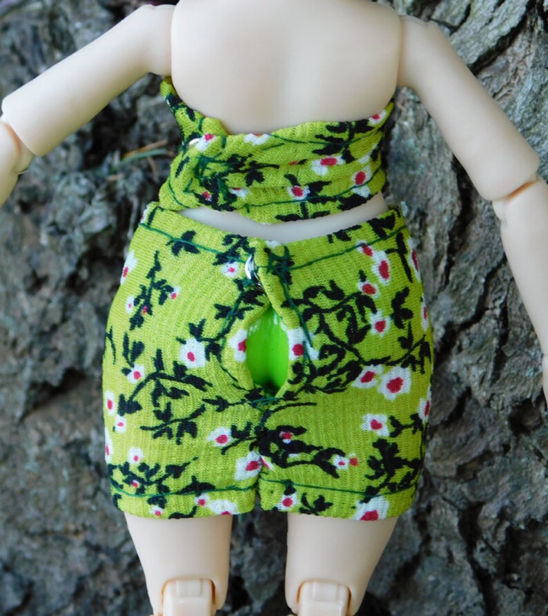 May include: A green and white floral print skirt with a black floral design. The skirt has a zipper down the back.