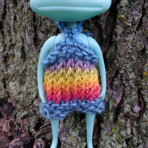 May include: A blue, purple, yellow, orange, and pink knitted halter top with a sparkly finish.