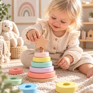 May include: A wooden stacking toy featuring a central post on a circular base, topped with a star-shaped piece. The toy includes several smooth, pastel-colored rings in shades of pink, yellow, blue, and green, arranged in a conical shape.