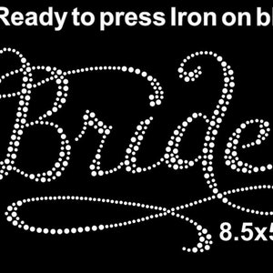 May include: White iron-on rhinestone design that says "Bride" in a cursive font. The design is 8.5 inches by 5 inches.
