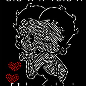 May include: Black iron-on transfer featuring a cartoon character design made of white rhinestones. Two red heart shapes are on the left. The text "bling iron on" is at the bottom. The design measures 8.5 inches wide by 10.5 inches high.