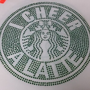 May include: Green rhinestone design of the Starbucks logo, featuring a mermaid with a crown and the word "Starbucks" around the outside.