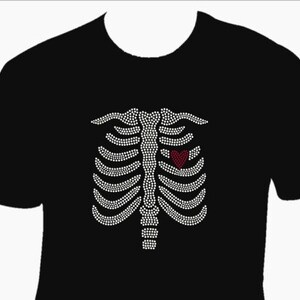 May include: Black t-shirt with a white rhinestone design of a ribcage with a red heart in the center.