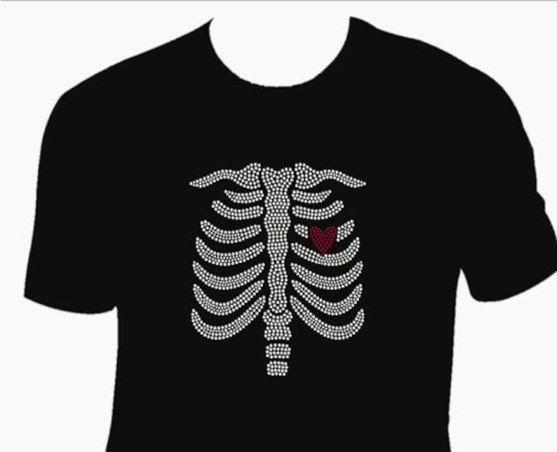 May include: Black t-shirt with a white rhinestone design of a ribcage with a red heart in the center.