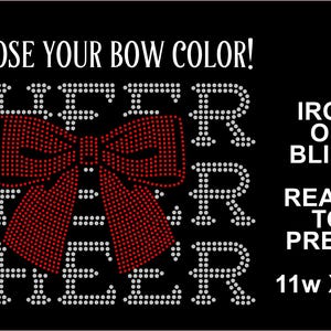 May include: Black iron-on bling design with the word "CHEER" in white rhinestones, featuring a red rhinestone bow. The text "CHOOSE YOUR BOW COLOR!" is above the word "CHEER". The design is 11 inches wide and 7 inches high.