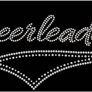 May include: Rhinestone design of the word "Cheerleader" in a white script font with a white diamond shape underneath.