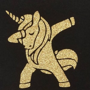 May include: A gold glitter unicorn silhouette in a dabbing pose on a black background.