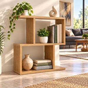 May include: A light oak wood bookshelf with an S-shaped design featuring two main levels. The shelf holds a potted trailing plant, a white abstract sculpture, a small potted green plant, three upright books, a ceramic vase, and three stacked books.