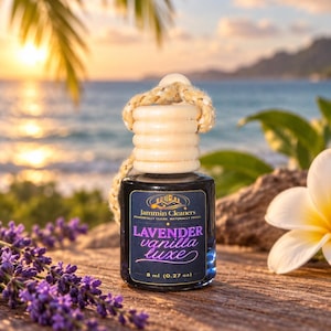 Peut inclure: Un petit flacon en verre de désodorisant avec un bouchon en bois et une cordelette de suspension. L'étiquette porte le texte Jammin Cleaners, Lavender vanilla luxe et 8 ml. Le flacon est de couleur sombre et contient un parfum liquide.