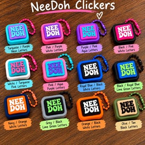 May include: A collection of twelve square NeeDoh Clickers, each featuring a central button with the text 'NEE DOH' and a small ball chain. The items come in various colour combinations including turquoise, pink, purple, black, white, blue, orange, grey, and olive.