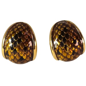 May include: A pair of dome-shaped earrings featuring a polished gold-tone metal border and a central inlay with a repeating, overlapping scale pattern in shades of amber, brown, and metallic gold, creating a textured, glossy appearance.