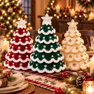 May include: Three cone-shaped crochet Christmas trees in red, green, and cream. Each tree features scalloped white trim, small white snowflake appliqués, and round pearl-like beads. A white crocheted star sits atop each tree, adding a festive touch.