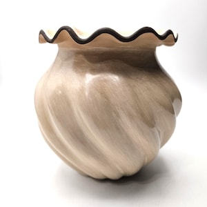 Op de afbeelding: Een beige keramische vaas met een spiraalvormig ontwerp en een gerimpelde rand. De rand is omlijnd met een donkerbruine kleur. De vaas heeft een bolle vorm en staat op een witte achtergrond.