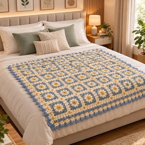 Könnte beinhalten: Eine handgefertigte Häkeldecke mit einem sich wiederholenden Granny-Square-Muster in den Farben Hellblau, Creme und Gelb. Die quadratischen Motive sind zu einer großen rechteckigen Decke mit einem wellenförmigen Rand aus hellblauem Garn verbunden.
