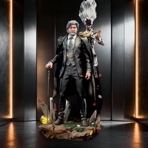 May include: A detailed figurine of a gray-haired man in a black suit, vest, and tie, holding a thin cane. Behind him stands a spectral, white-haired figure with a floral-like face. They are positioned on a rocky base with scattered red petals.
