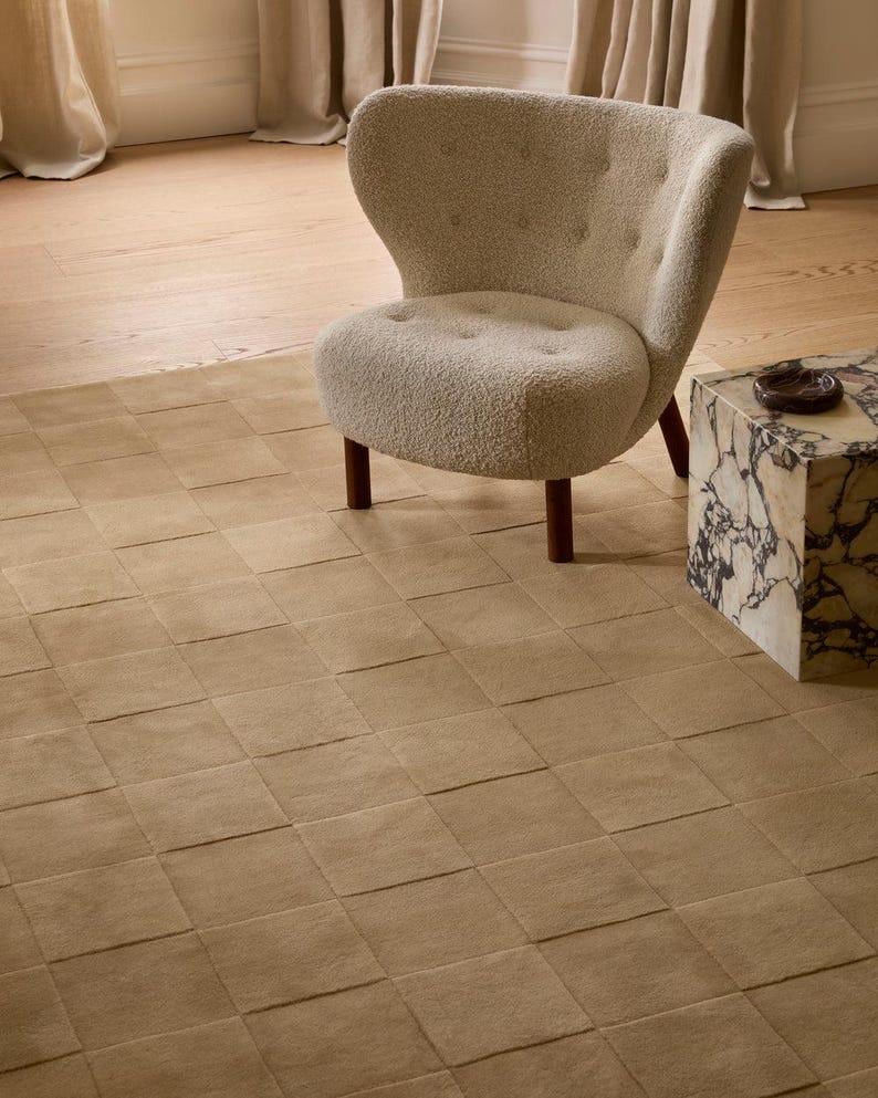 Modern toffee brown geometric rug featuring a raised checkerboard pattern, styled beneath a wooden desk in a sophisticated home office.