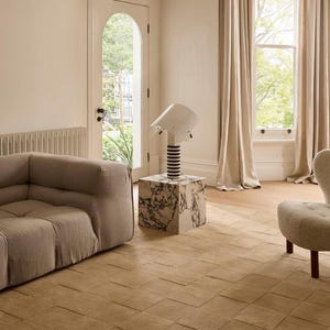 Toffee brown textured area rug with a raised square checkerboard design styled in a modern living room with a neutral sofa and elegant furniture.