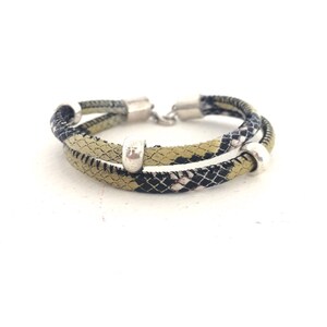 May include: A double-layered bracelet with a black and green snake skin pattern and silver beads.